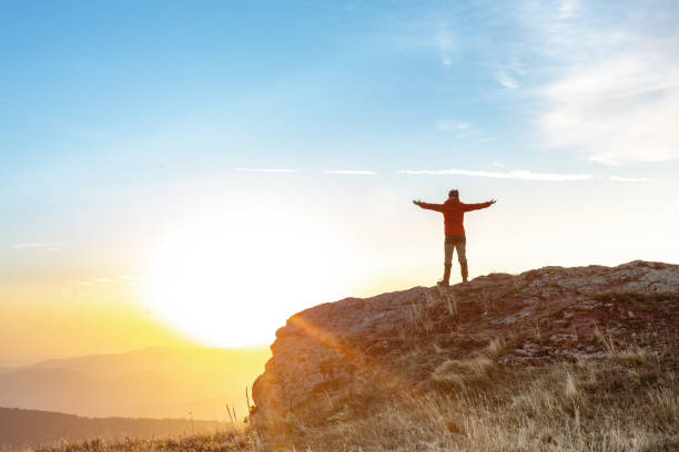 istock Female hiker stands arms outstretched on mountain top 1711863315