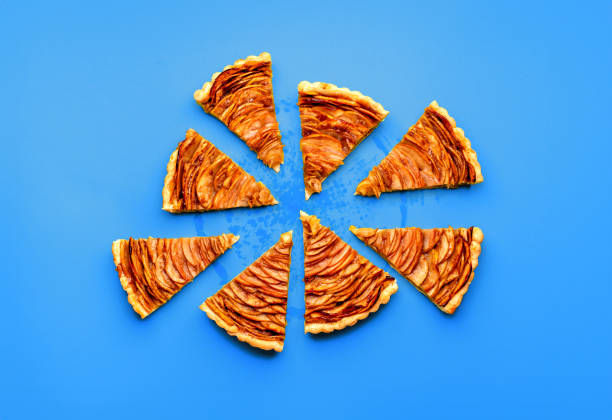 istock Sliced apple pie minimalist on a blue table, above view 1711905990