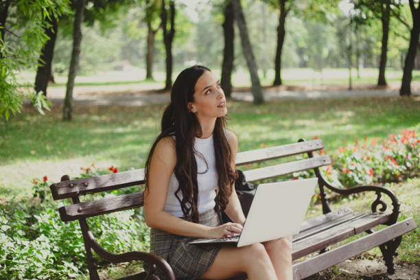 istock Woman using a laptop outdoors stock photo 1711913241