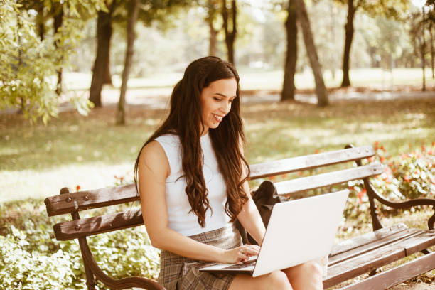 istock Woman using a laptop outdoors stock photo 1711915472