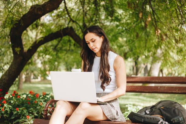 istock Woman using a laptop outdoors stock photo 1711918693