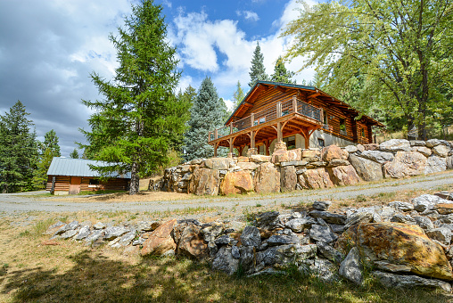 A rustic chalet style log home and log shop garage with metal roof in the mountains of Coeur d'Alene, Idaho, USA. Coeur d’Alene is a city in northwest Idaho. It’s known for water sports on Lake Coeur d’Alene, plus trails in the Canfield Mountain Natural Area and Coeur d’Alene National Forest.