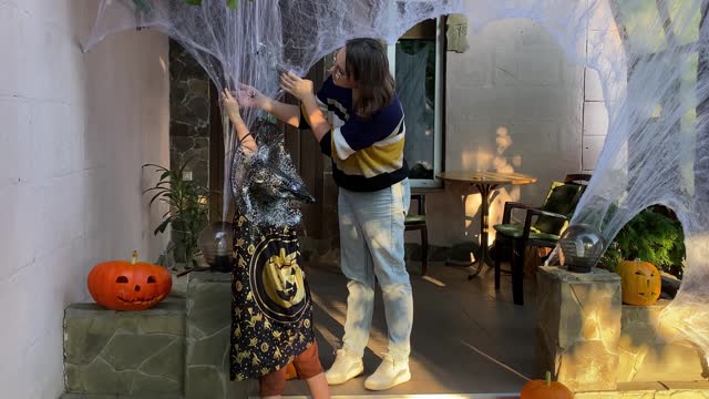 Family Prepares Halloween Decorations with Joyful Teamwork