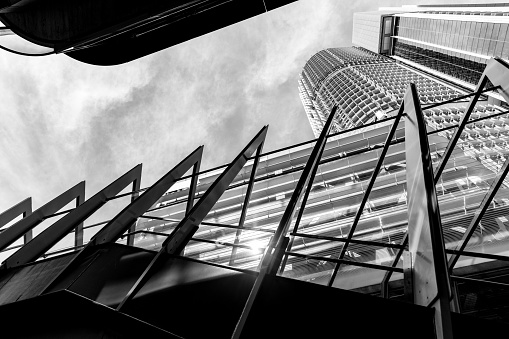 Black and white low angle view of pedestrian bridge withhmodern office buildings, skyscrapers, Sydney NSW, background with copy space, full frame horizontal composition