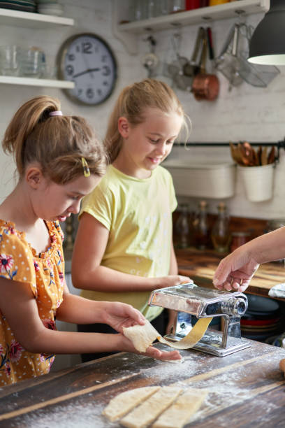 istock Cute Girls Preparing Pasta in Domestic Kitchen 1711975667