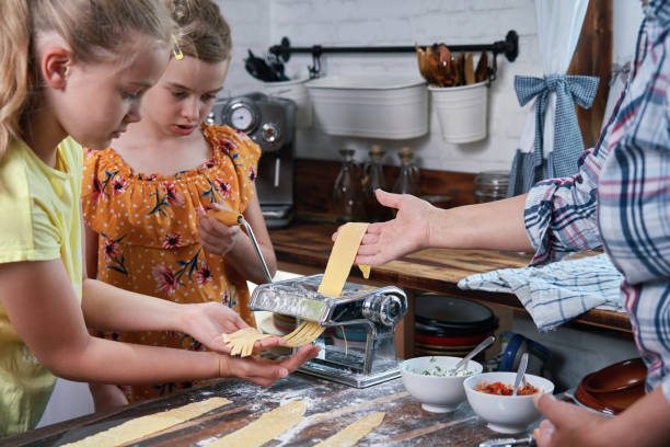 istock Cute Girls Preparing Pasta in Domestic Kitchen 1711976223
