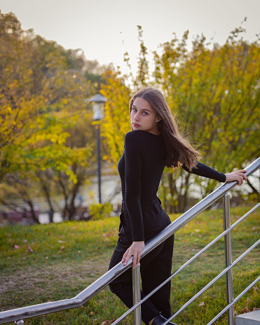 Beautiful girl posing on the steps in an autumn park