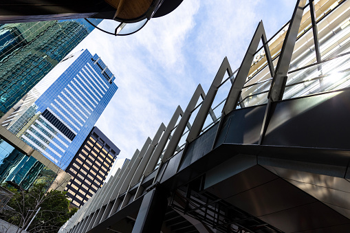Low angle view of pedestrian bridge with modern office buildings, skyscrapers, Sydney NSW, background with copy space, full frame horizontal composition