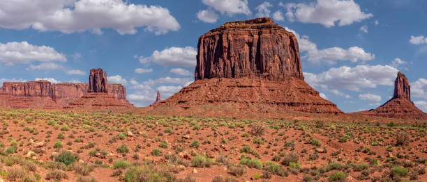 The Mittens and Merrick Butte Monument Valley, on the Arizona - Utah border, gives us some of the most iconic and enduring images of the American Southwest.  The harsh empty desert is punctuated by many colorful sandstone rock formations.  It can be a photographer's dream to capture the ever-changing play of light on the buttes and mesas.  Even to the first-time visitor, Monument Valley will probably seem very familiar.  This rugged landscape has achieved fame in the movies, advertising and brochures.  It has been filmed and photographed countless times over the years.  If a movie producer was looking for a landscape that epitomizes the Old West, a better location could not be found.  This picture of The Mittens and Merrick Butte was photographed from the Monument Valley Road north of Kayenta, Arizona, USA. merrick butte photos stock pictures, royalty-free photos & images