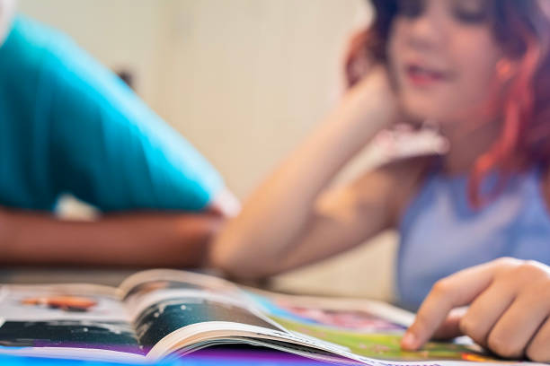 istock Brother and sister read magazine together 1712024135