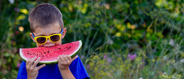 A child eats a watermelon. Selective focus. Nature