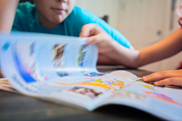 istock Brother and sister read magazine together 1712044059