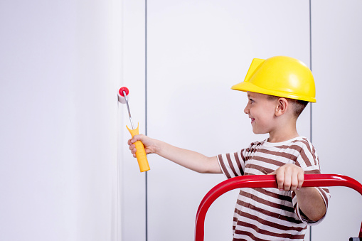 Boy painting wall during home renovation