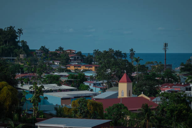 Panorama of the city of Limon in Costarica, view from the hill above the city, church and palm trees in the background with visible carribean sea. Panorama of the city of Limon in Costarica, view from the hill above the city, church and palm trees in the background with visible carribean sea. puerto limon stock pictures, royalty-free photos & images