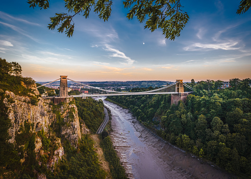 Distant view of  suspension bridge over a gorge  in summer at sunset