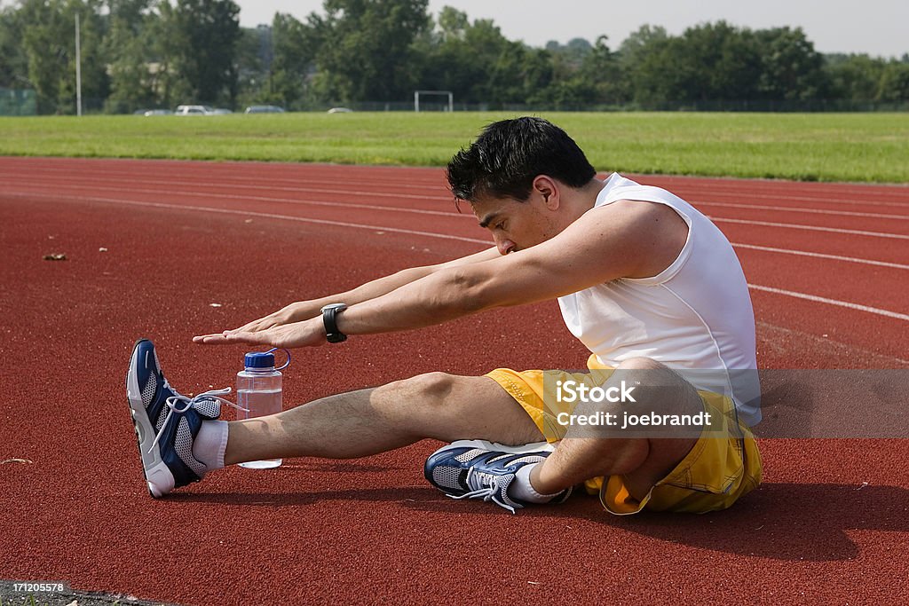 Atleta de estiramiento en pista - Foto de stock de Actividades y técnicas de relajación libre de derechos