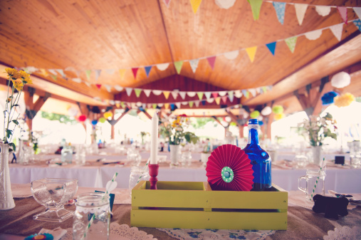 Outdoor pavilion decorated for a party.  Fun use of banners, pinwheels, bottles and flowers.