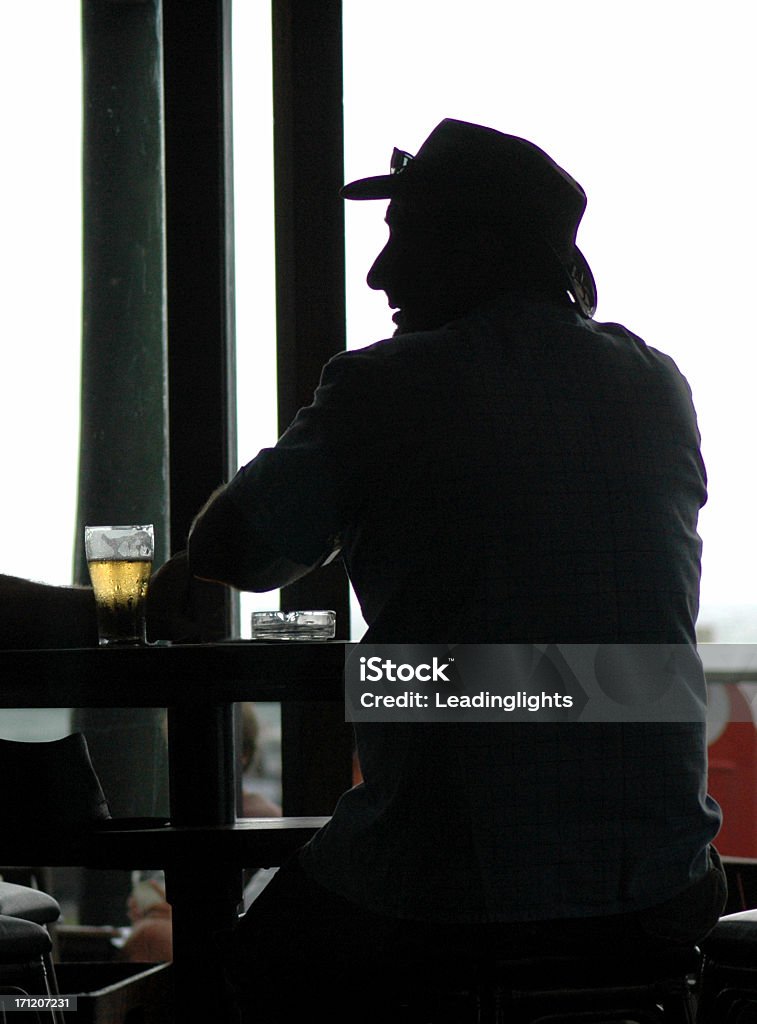 Man, Beer &amp; Ash Tray "An Australian relaxes in a bar with a beer, silhouetted." Adult Stock Photo