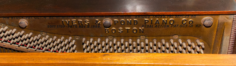 Piano Sound Resonating System string iron frame mechanism of old late 1800s upright grand piano.  Ivers and ponds piano company from Boston, Massachusetts. pre Great Depression musical instrument