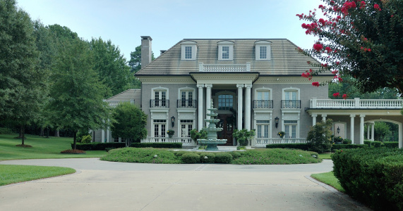 Houston, TX USA 07-27-2023 - A beautiful and retro styled luxury mansion with wonderful landscaping.