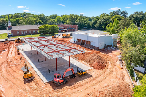 Construction site for a new gas station showing fresh dirt and unfinished building, unfinished parking lot and unfinished fuel island