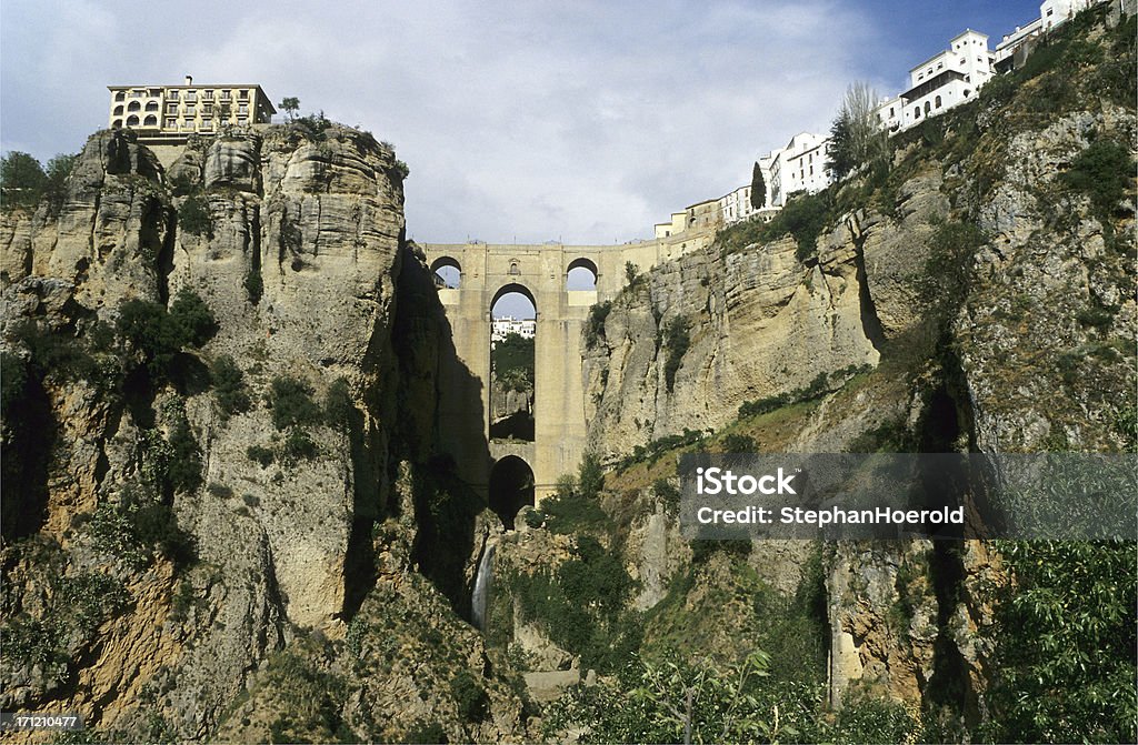 Ronda, Andalusia, Spain High up on the rocks a bridge that keeps Ronda together. The parador is visible on the left cliff. Andalusia Stock Photo