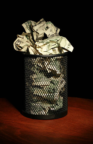 istock Crumpled money in a black waste basket 171210532