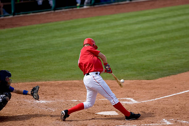 Baseball player hitting ball during a game stock photo