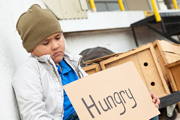 istock Sad little boy holding a hungry sign 171211068