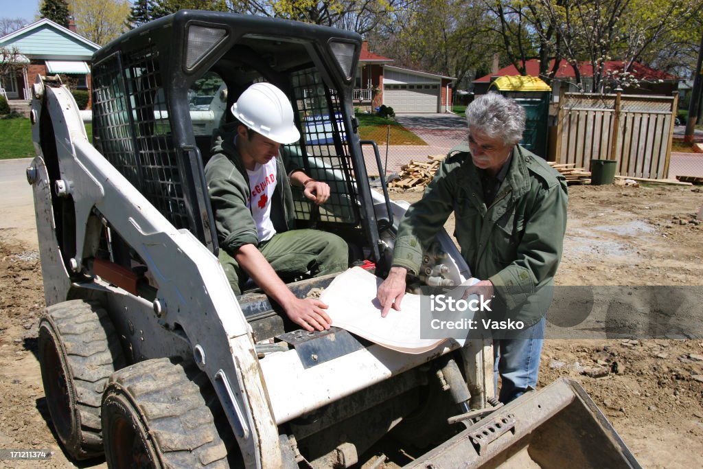 Landscaping Project Picture of a designer explaining what needs to be done to the bobcat operator. Landscaped Stock Photo