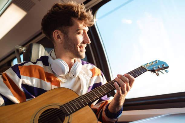 istock Young man playing a guitar during a train ride 1712113892