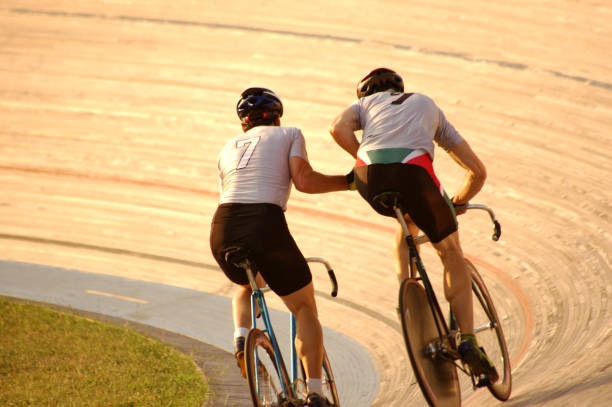 The Launch One teammate uses his momentum to catapult the other rider to full speed.  Could also be used as celebrating a win or congratulating each other. velodrome stock pictures, royalty-free photos & images