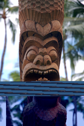 Polynesian tiki (carved image) looks over Hawaiian resort on island of Kauai.