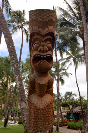 Polynesian tiki (carved image) looks over Hawaiian resort on island of Kauai.
