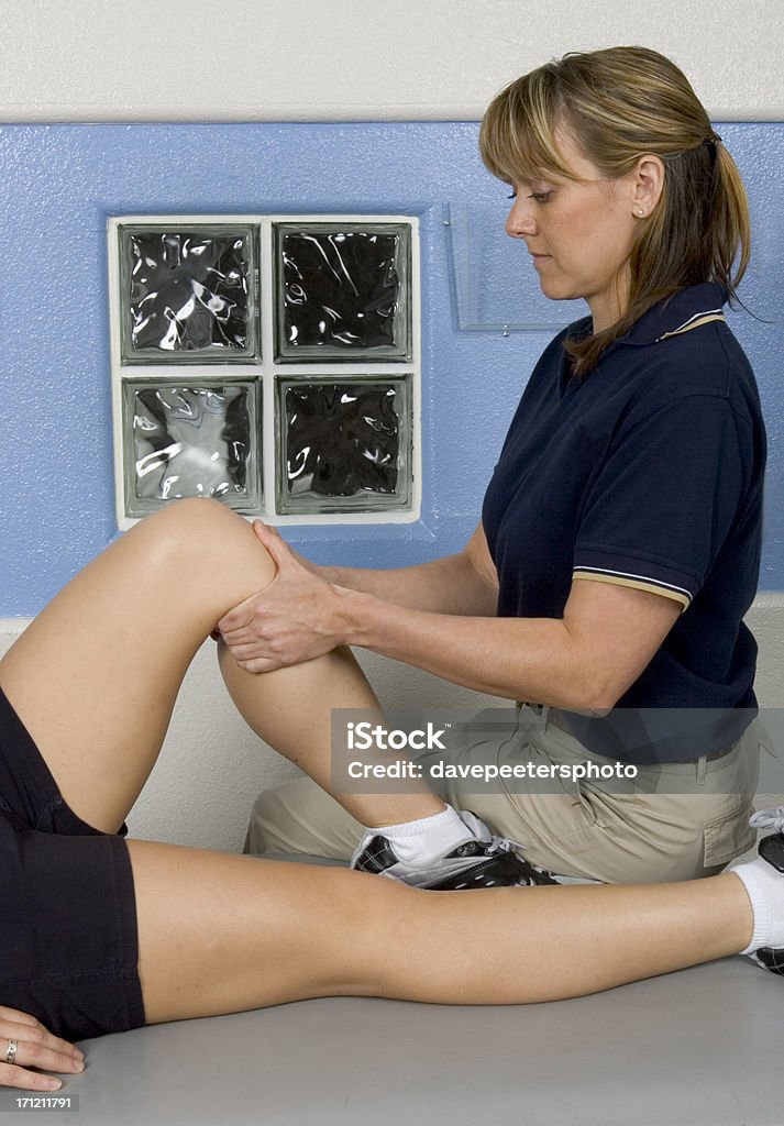 Knee Massage Therapy Female Athlete getting Knee Massage Therapy and Rehabilitation Alternative Therapy Stock Photo