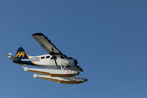 Richmond, Canada - 15th September, 2023: C-FEBE de Havilland Canada DHC-2 Beaver, a single engine propeller driven seaplane  operated by Harbour  Air, coming in to land at Vancouver Airport South, Richmond, BC, Canada. Some motion blur in the propeller.