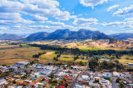 Remote rural agriculture town Gloucester at Barrington tops scenic mountain peaks in Australia - aerial landscape.
