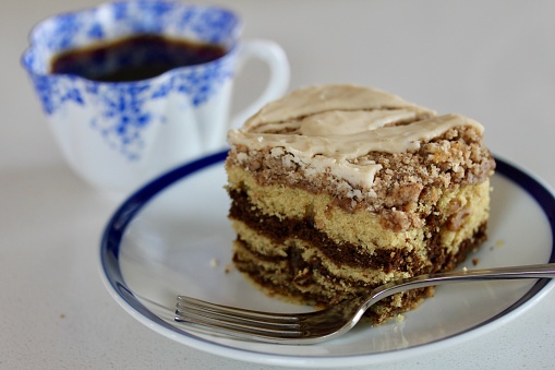 Plated coffee cake and a cup of coffee in the background