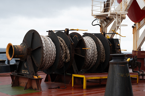 mooring winches with hawsers wrapped on it at the poop deck of a cargo ship