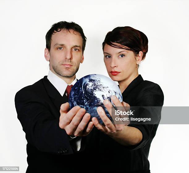 Foto de Homem E Mulher Em Traje De Negócios Segurando O Mundo e mais fotos de stock de Adulto