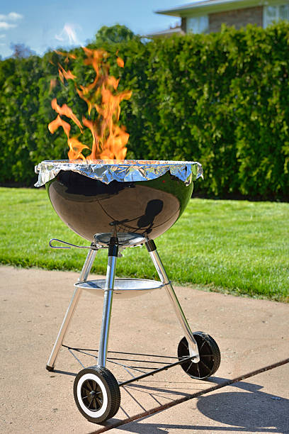 istock Backyard Charcoal BBQ with flames on concrete backyard patio 171221277