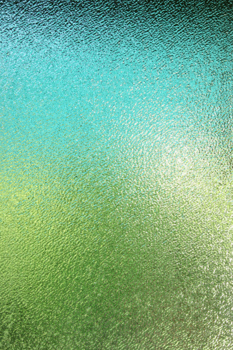 Frosted glass window in bathroom shower, outside colors shining through texture