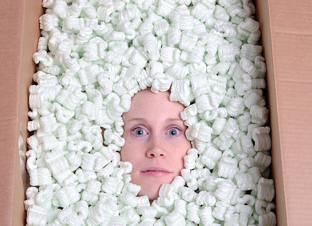 Staring. Concept image of a freaky head burried in a box of packaging peanuts. gawp stock pictures, royalty-free photos & images