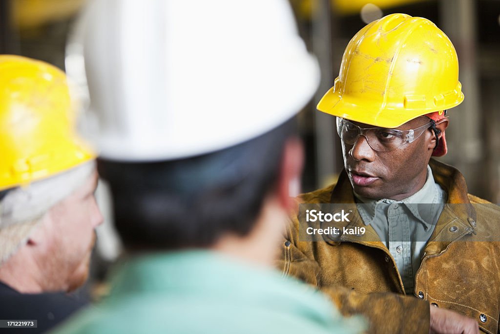 Multi-ethnischen Arbeitnehmer mit Schutzhelm, reden - Lizenzfrei Berufliche Beschäftigung Stock-Foto