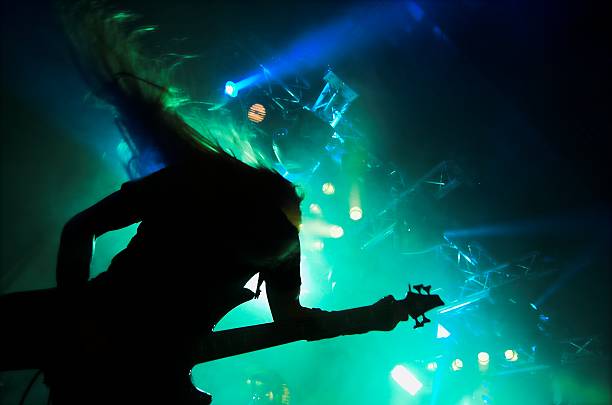 Silhouette of heavy metal guitar player performing live Headbanger hair band stock pictures, royalty-free photos & images