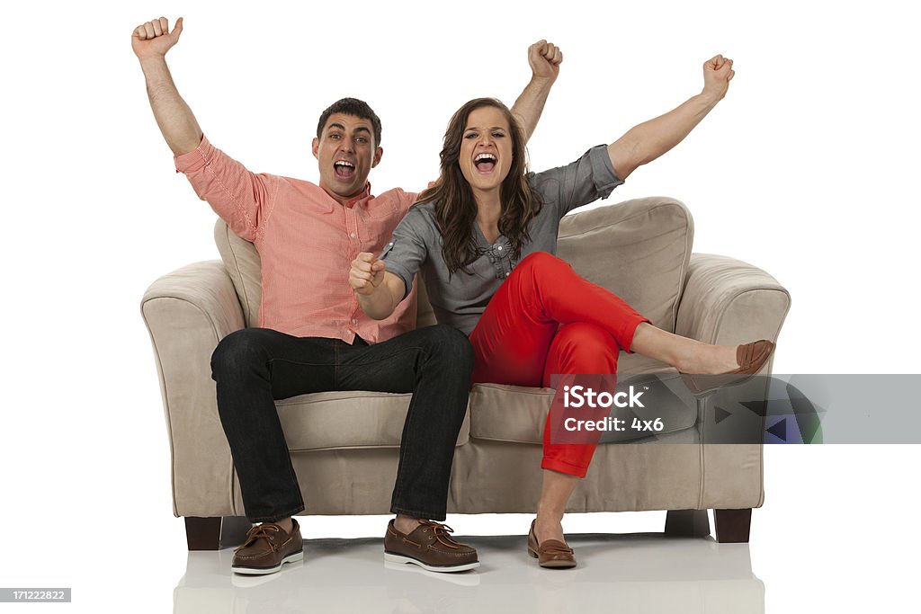 Portrait of a couple sitting on couch and shouting Cut Out Stock Photo