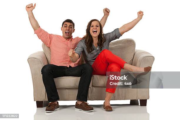 Portrait Of A Couple Sitting On Couch And Shouting Stock Photo - Download Image Now - Cut Out, Excitement, People