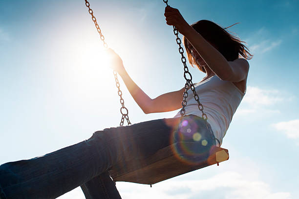 istock Girl Swinging Against Sun and Blue Sky 171222909