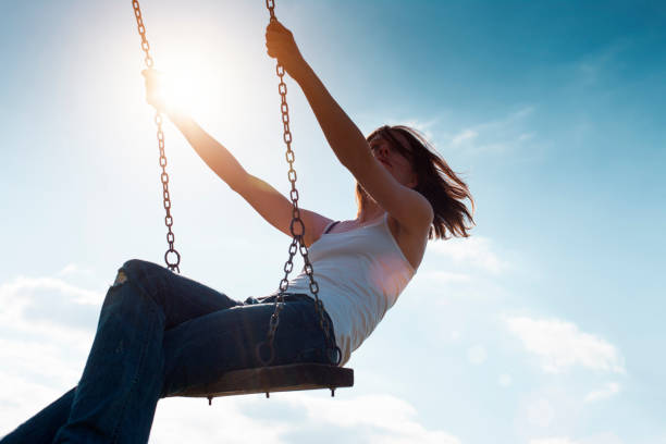 istock Girl Swinging Against Sun and Blue Sky 171223829