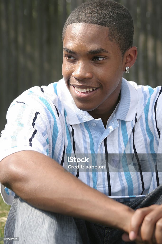 Casual Look Young man sitting outdoors. Please view all pictures of this Adolescence Stock Photo